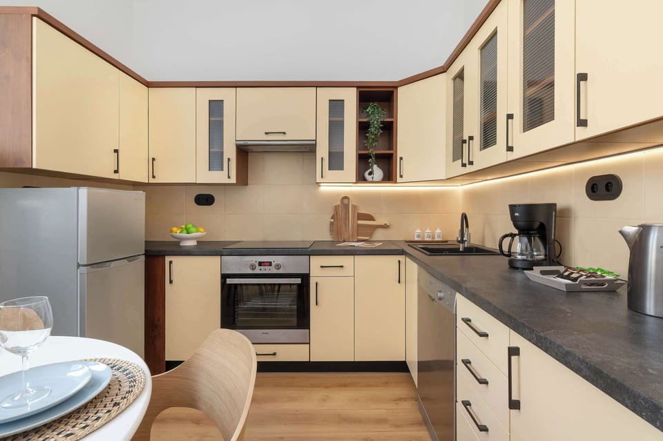 A modern kitchen with light-colored cabinets and built-in appliances. The layout offers plenty of workspace.