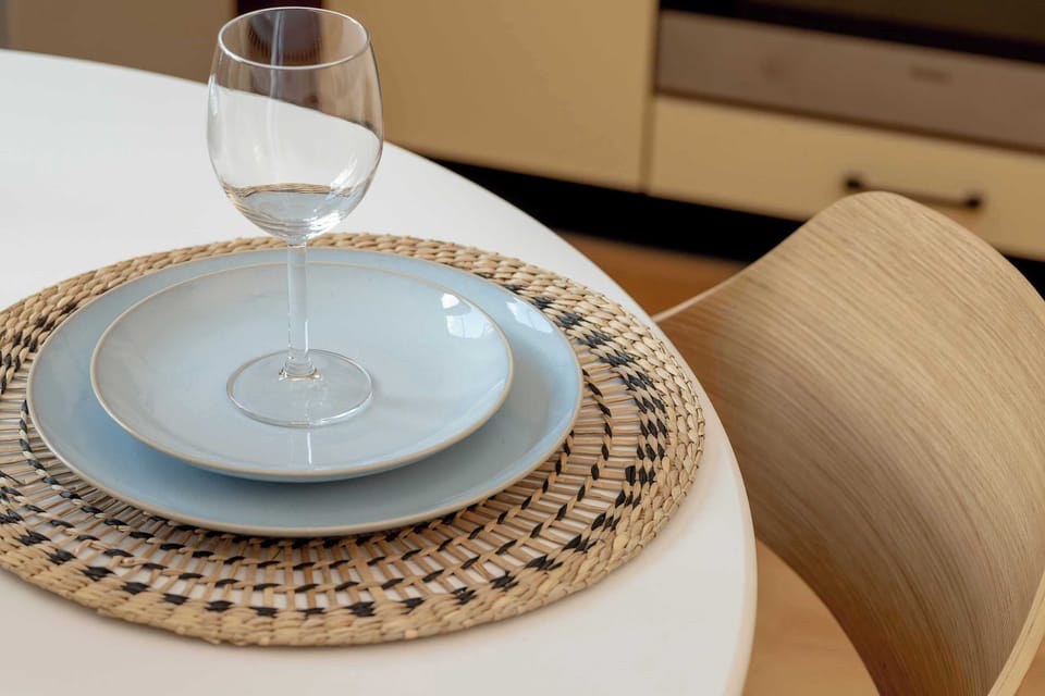A close-up of a dining table with a plate and glass. Elegant tableware creates a welcoming dining setting.