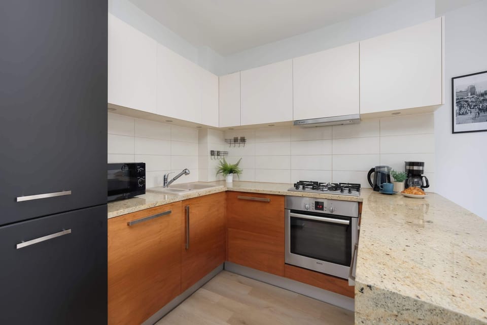 Bright corner kitchenette featuring sleek cabinetry, generous countertop space, and contemporary finishes.