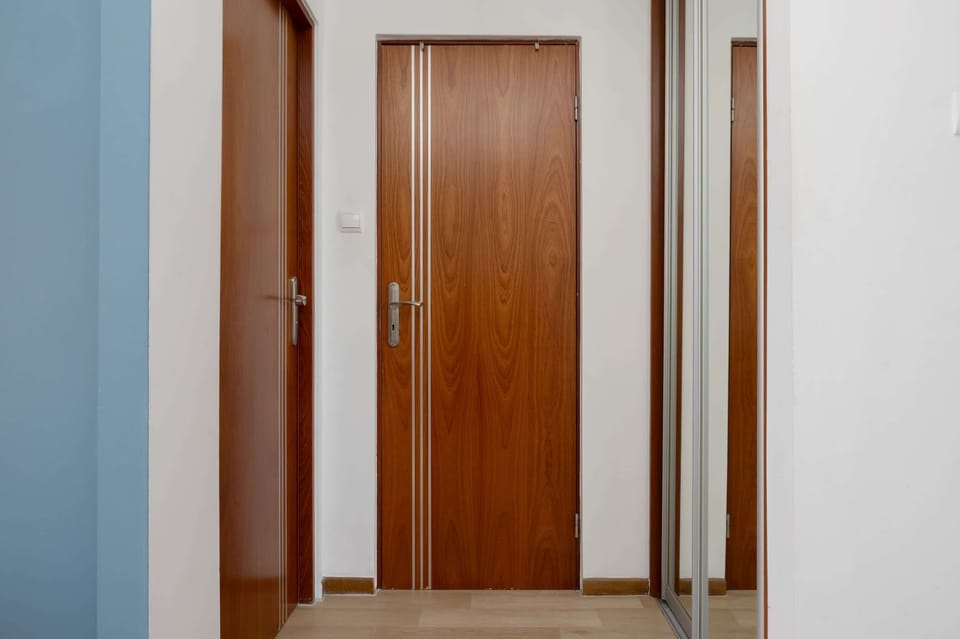 Entrance hallway with built-in storage and wooden doors, offering convenient access to all rooms.