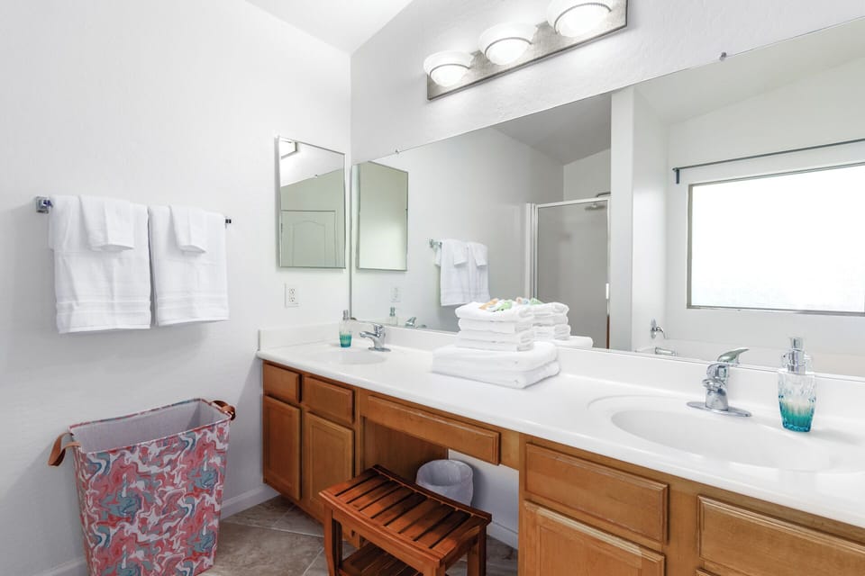 Spa-inspired ensuite bathroom featuring dual vanities, a soaking tub, and walk-in shower.