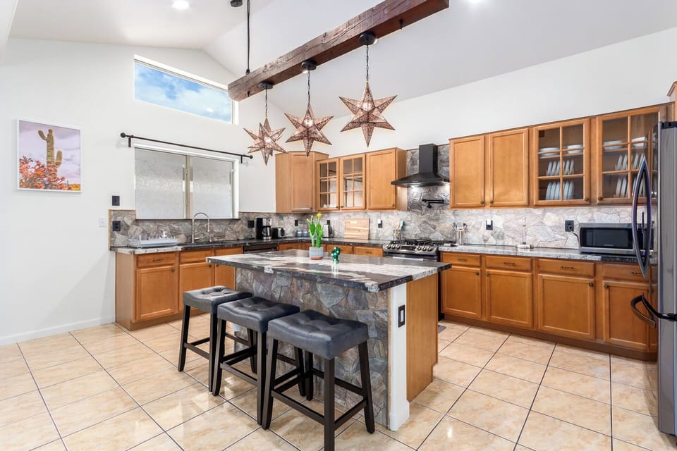The fully equipped kitchen features stainless steel appliances, ample counter space, and everything needed for group meals.