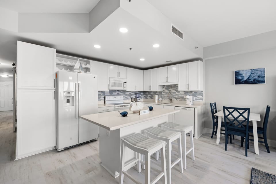 Your bright, fully-equipped kitchen awaits with modern appliances, spacious island seating, and a cozy dining nook—perfect for preparing meals and gathering together during your stay.