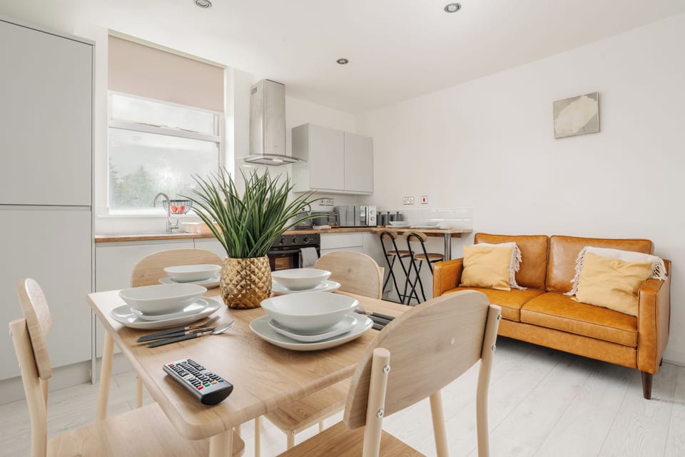 Open-plan living, dining, and kitchen area designed for relaxing and socialising. Features a comfortable two-seater sofa, Smart TV, four-seater dining table, and a fully equipped kitchen with everything needed for a comfortable stay.