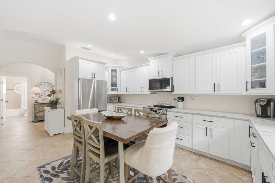 Gather around the spacious kitchen with bright white cabinetry, quartz countertops, and stainless steel appliances—everything you need to cook, dine, and connect with loved ones in a light-filled, inviting space.