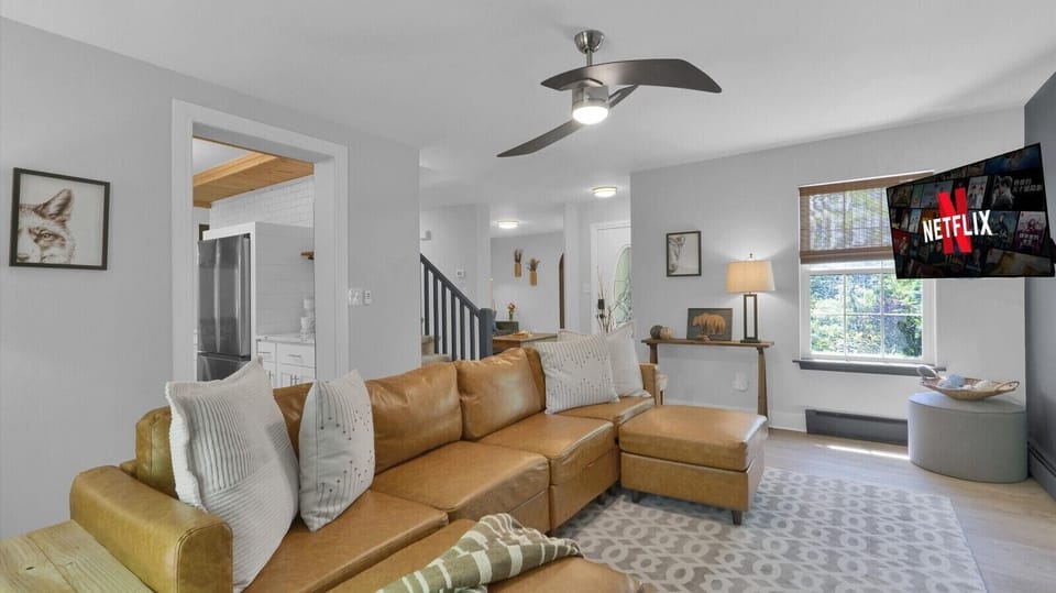 Right behind the couch is an open doorway leading directly to the kitchen and dining area.