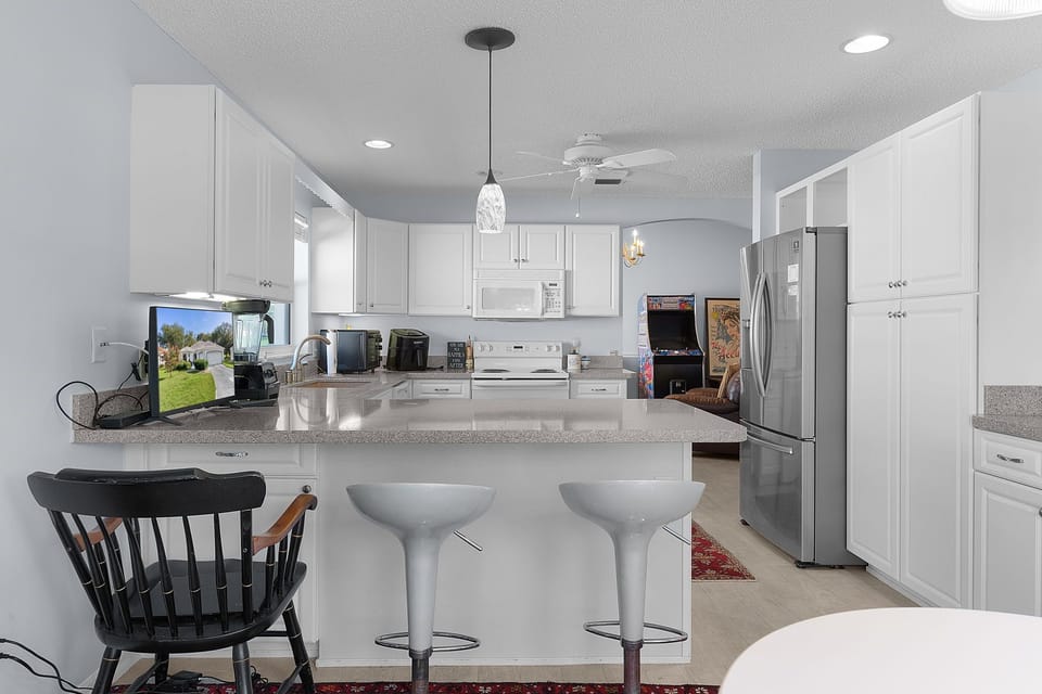 Cook, entertain, and gather around this spacious kitchen island with modern appliances, bright white cabinetry, and gleaming countertops—your perfect spot for morning coffee or evening meals.