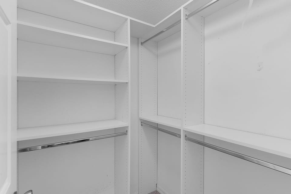 Your spacious walk-in closet features built-in shelving, multiple hanging rods, and ample storage to keep your belongings organized during your stay.