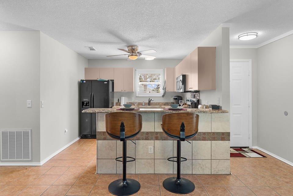 A fully equipped kitchen with a breakfast bar awaits you, ready for your morning coffee or a casual meal with loved ones.