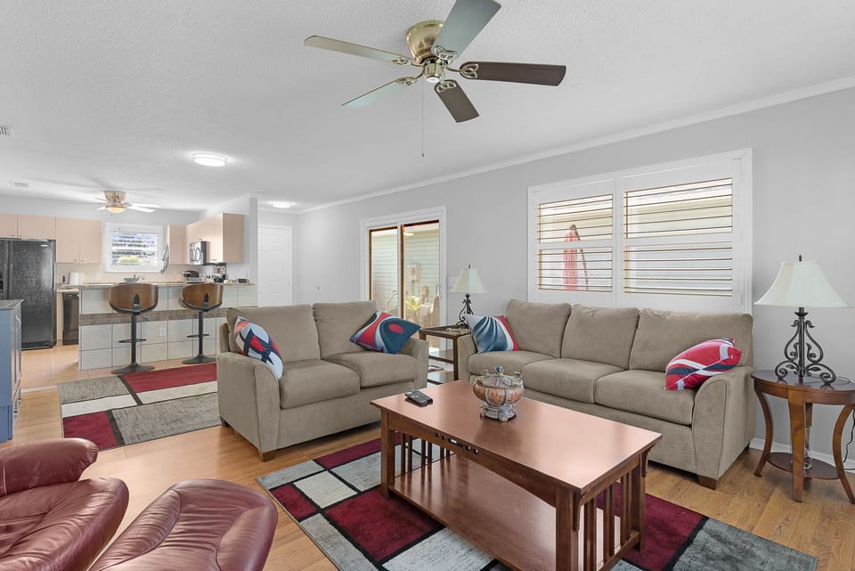 Relax in your comfortable living room with plush sofas, warm hardwood floors, and an open layout flowing seamlessly into the kitchen—perfect for unwinding after a day of exploring.