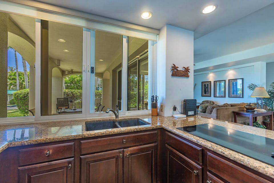 From your kitchen, you'll look out through sliding windows to lush tropical greenery and your private living areas beyond.