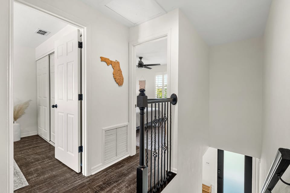 Bright upstairs hallway with Florida charm and modern touches—your serene retreat awaits at the top of the stairs.
