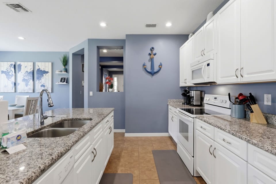 Fully equipped kitchen with spacious granite counters and seating for casual dining.