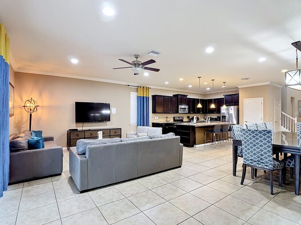 Wide-angle view showcasing the expansive living area, dining space, and fully equipped kitchen in one inviting layout.