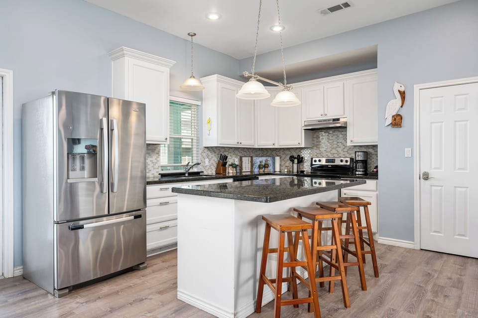 Fully stocked kitchen with a large bar for entertaining and meal prepping.    