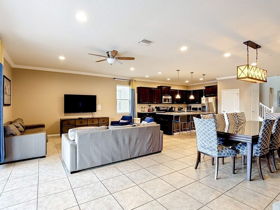 Wide-angle view showcasing the expansive living area, dining space, and fully equipped kitchen in one inviting layout.