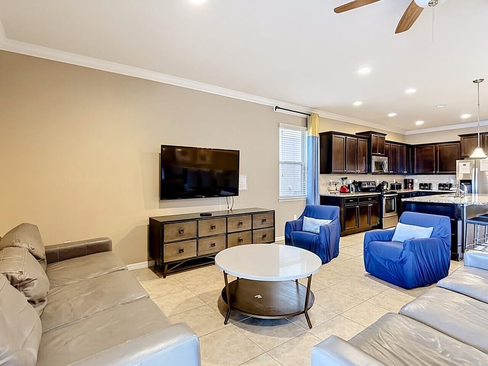 Spacious living room with comfortable seating, large smart TV, and open access to the gourmet kitchen.