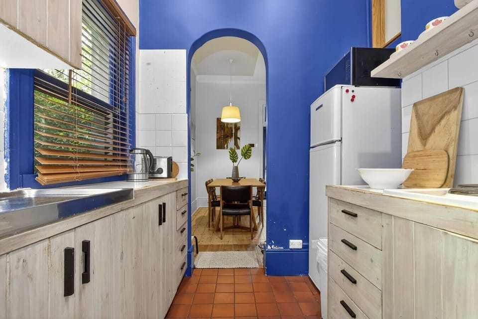 Vibrant blue kitchen with arched entry to dining room