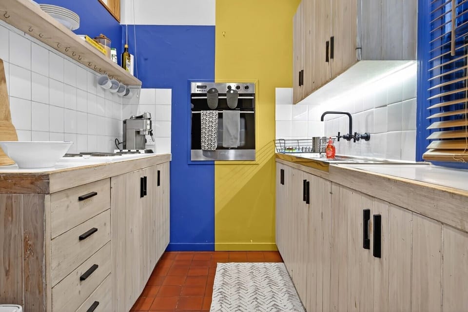 Colourful kitchen with timber cabinetry & espresso machine
