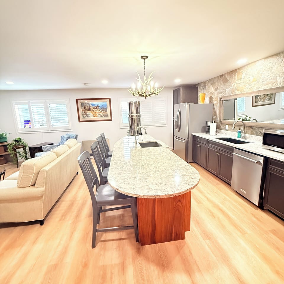 Granite top entertainment island with seating, wine fridge, second sink.