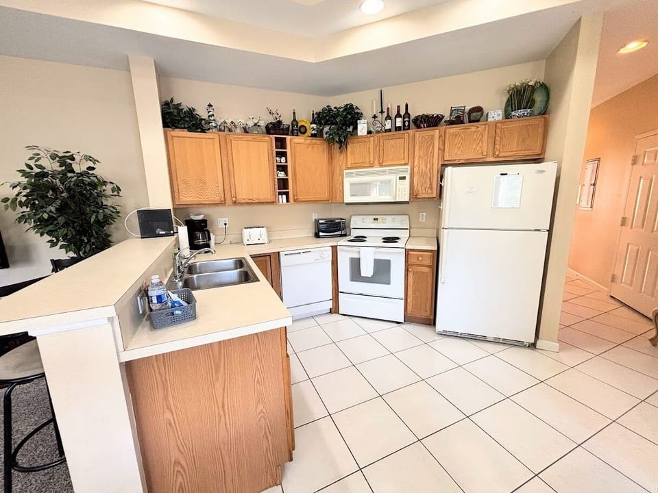 Fully equipped kitchen with full-size appliances, breakfast bar seating, and an open layout into the main living area.