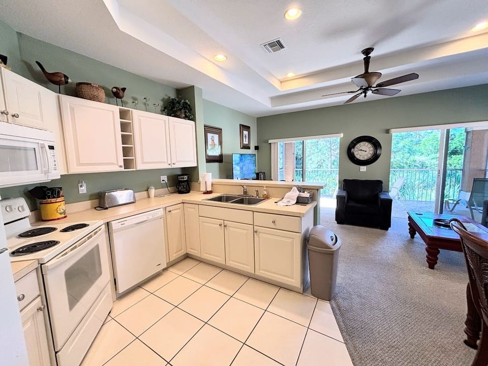 Bright open kitchen and living area with full-size appliances, high ceilings, and a comfortable layout.