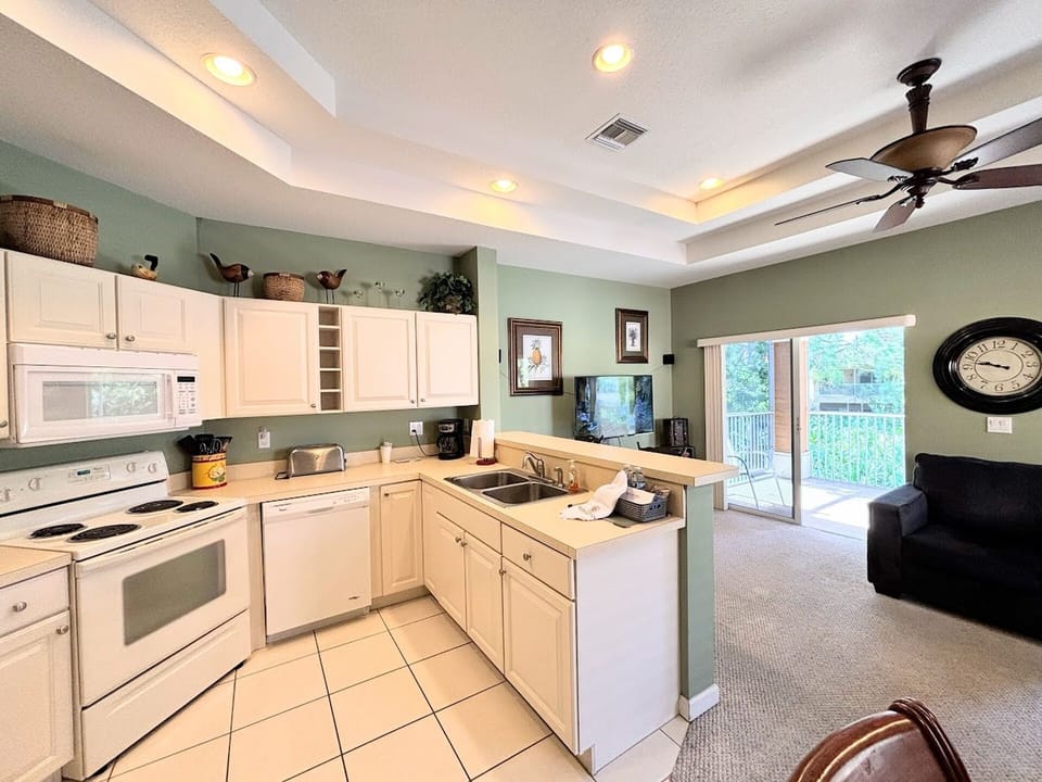 Open-concept kitchen and living space featuring full-size appliances, high ceilings, and easy access to the main living area.