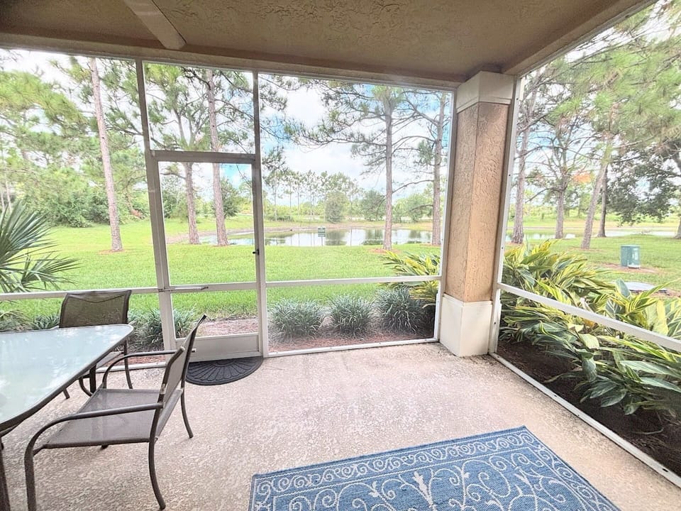 Screened patio with relaxing outdoor seating and beautiful views of the surrounding landscaping and pond.