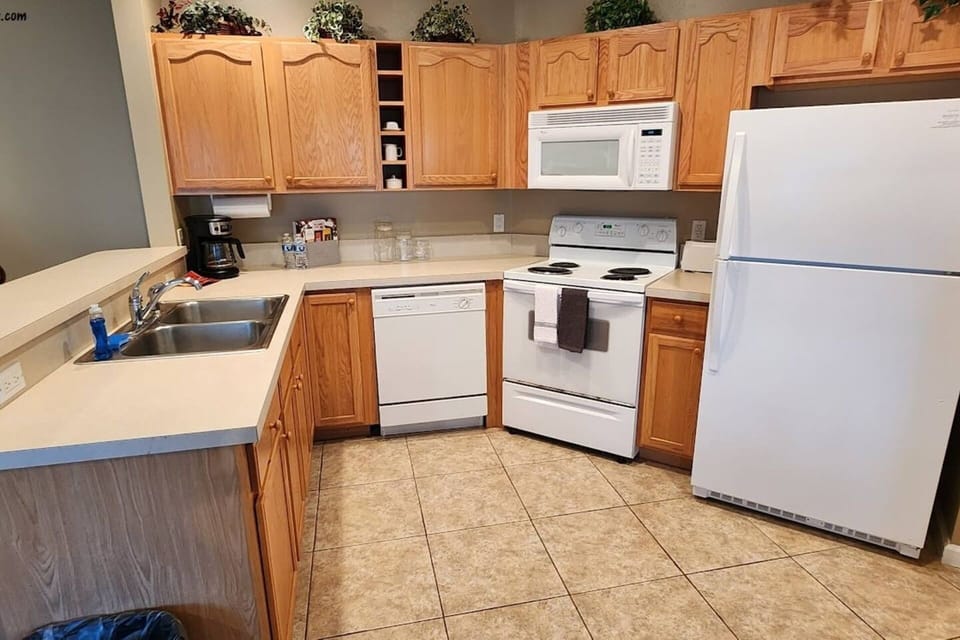 Functional kitchen with full-size appliances, cabinet storage, and an open layout into the dining and living areas.