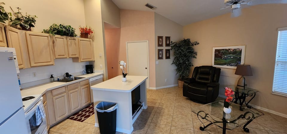 Open kitchen and living space featuring full-size appliances, breakfast bar seating, and a comfortable sitting area.