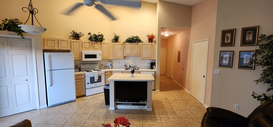 Spacious kitchen with full-size appliances, tile flooring, breakfast bar seating, and easy access to the main living area.