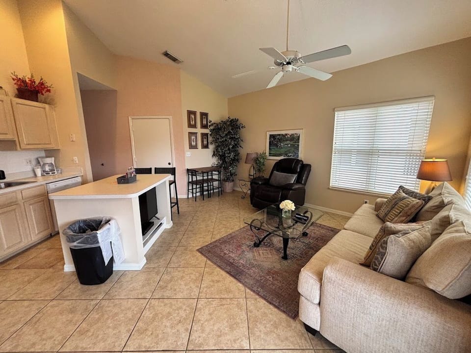 Bright living and kitchen area with vaulted ceilings, comfortable seating, and a relaxed open layout.