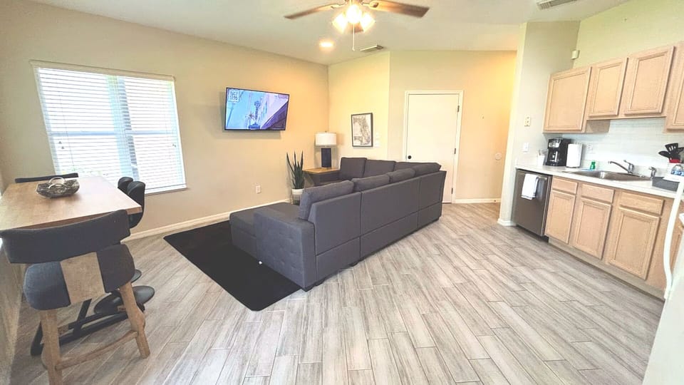 Open living and dining space with updated flooring, cozy seating, and a bright kitchen layout.