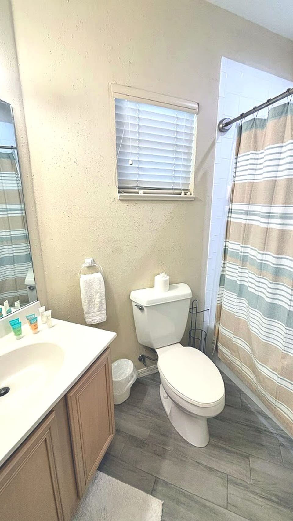 Bathroom featuring vanity storage, toilet, tile flooring, and a tub/shower combination.
