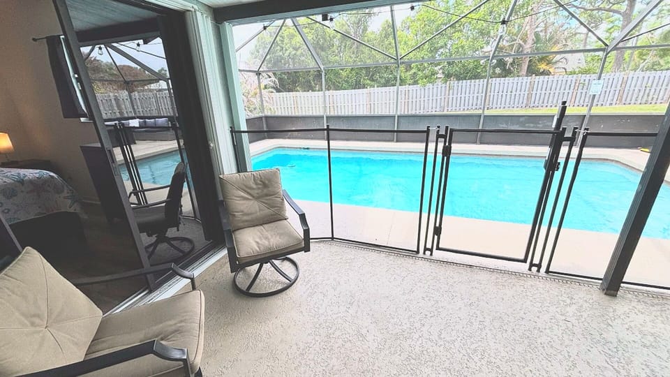 Covered patio seating with views of the screened-in private pool.
