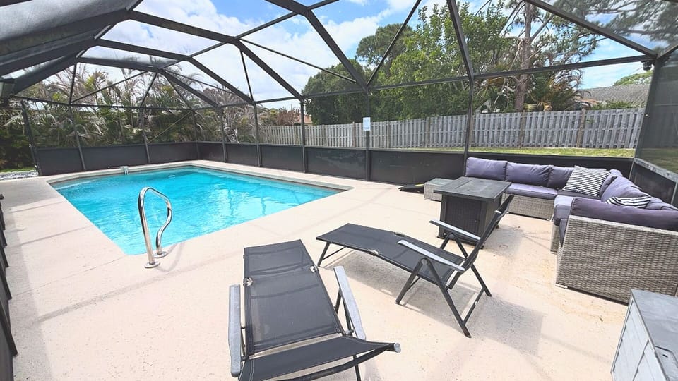 Screened pool patio with lounge seating, outdoor furniture, and a relaxing private pool area.