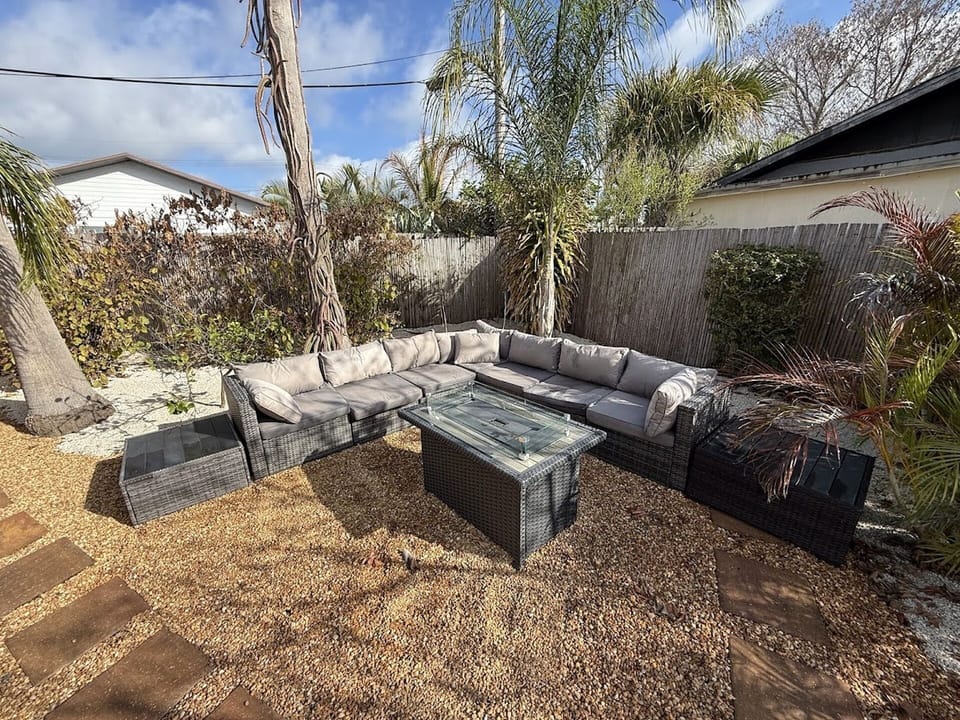 Private outdoor seating area with comfortable patio furniture, tropical landscaping, and a relaxed beach cottage feel.