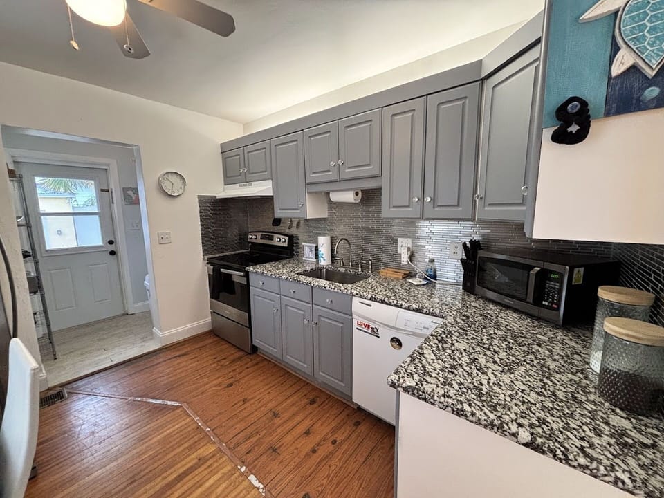 Updated kitchen with gray cabinetry, granite countertops, stainless steel appliances, and a bright functional layout.