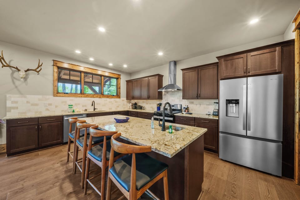 Spacious Kitchen has Center Granite Top Island and Stainless Fridge