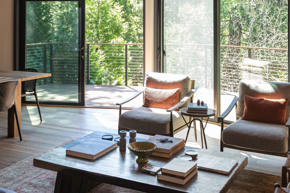 Floor-to-ceiling forest views from the sitting room — the trees are practically inside the room.