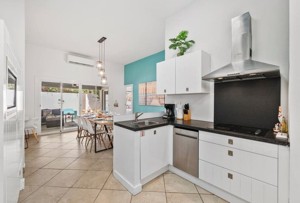 Open-concept kitchen with induction stove, modern appliances, and easy access to the outdoor dining and pool areas.