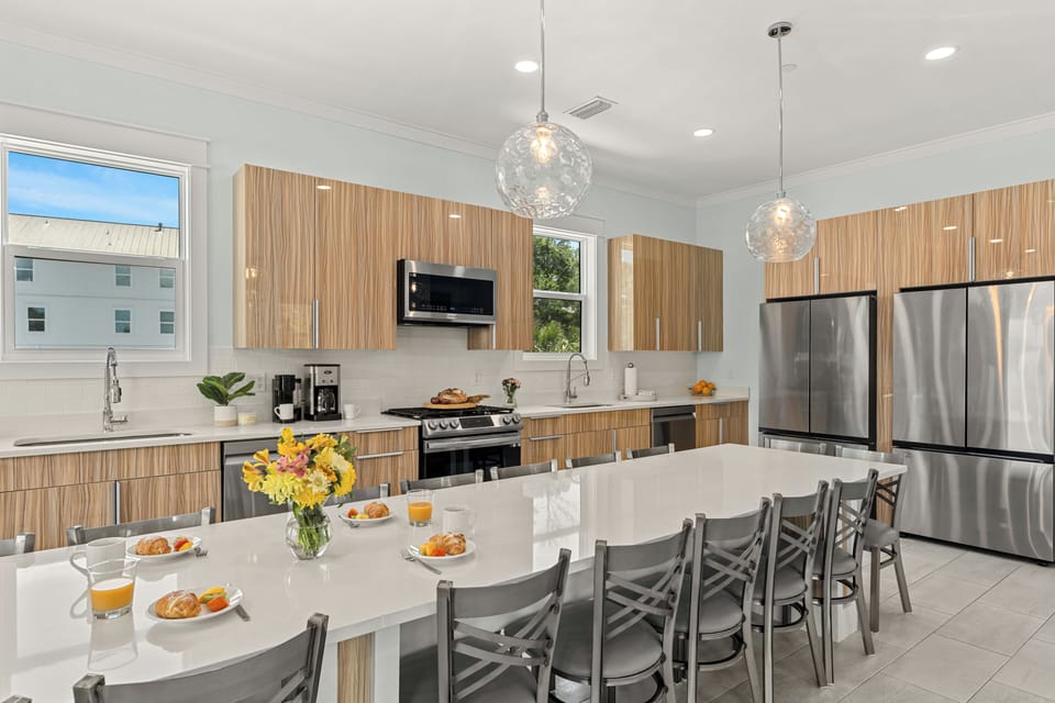 Gather around the oversized dining table with seating for the whole group, flanked by dual kitchens for effortless meal prep.