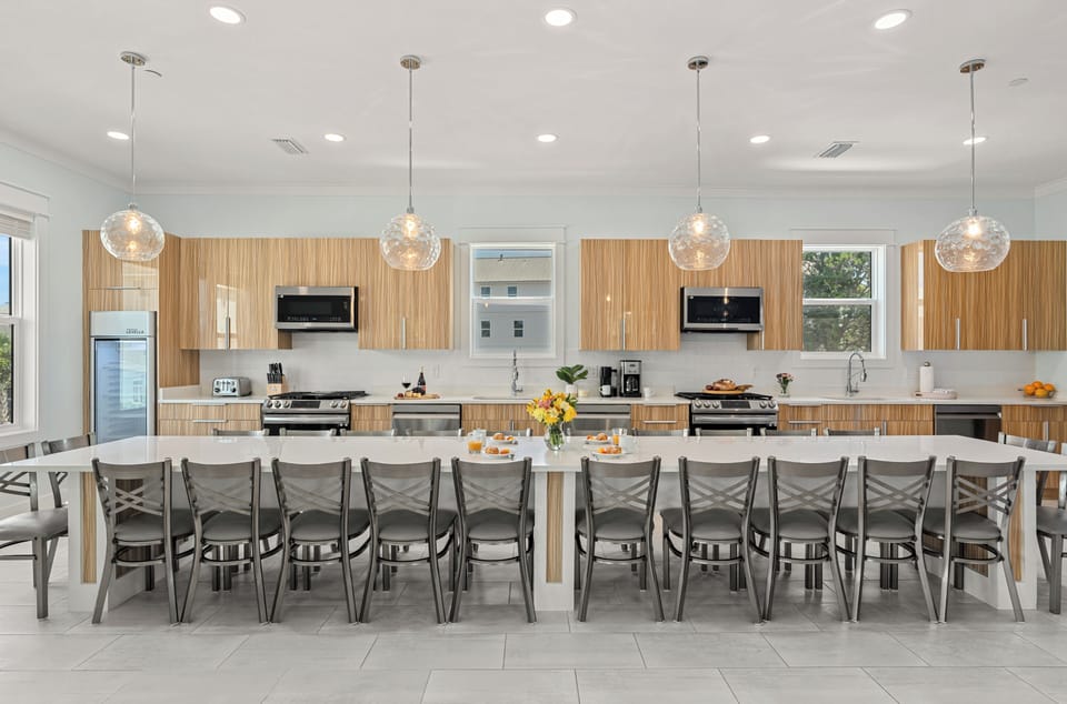 Gather around the oversized dining table with seating for the whole group, flanked by dual kitchens for effortless meal prep.