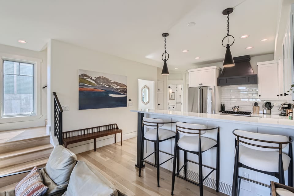 Modern chef’s kitchen with sleek finishes, stainless steel appliances, and bar seating perfect for morning coffee or après-ski bites.