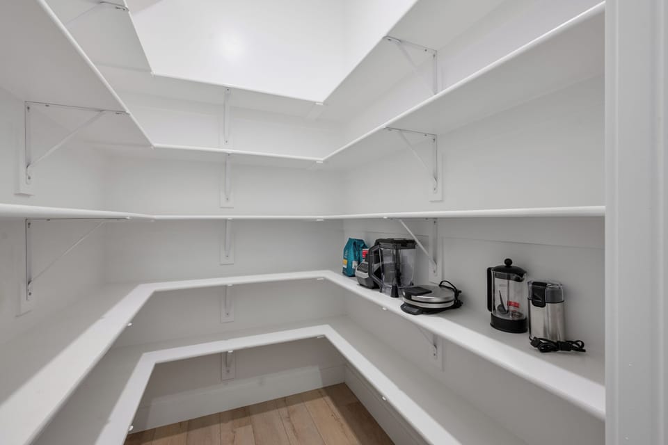 Massive walk-in pantry with wrap-around shelving for maximum storage and organization.