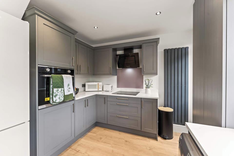 The modern kitchen is fully equipped with everything you could need to cook a meal away from home, featuring a dishwasher, oven, washing machine, toaster, kettle, microwave and coffee machine.