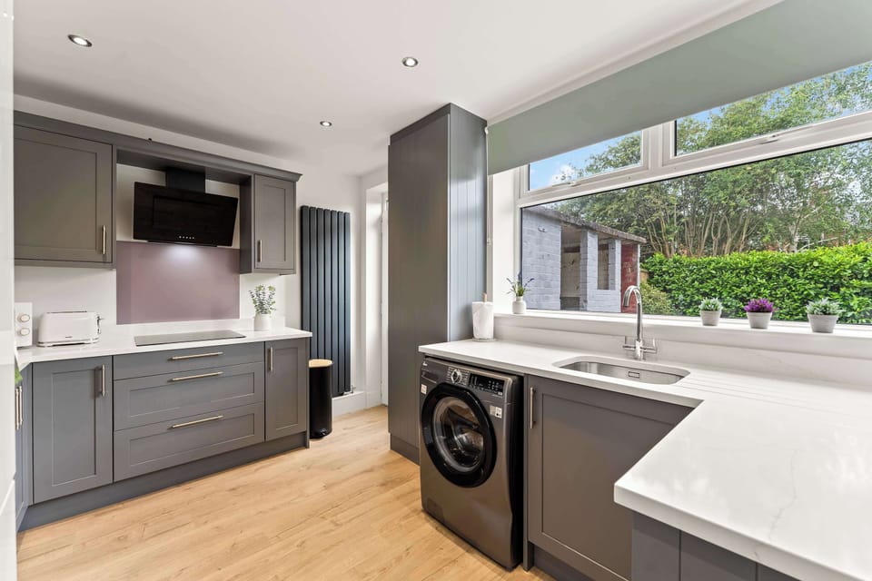The modern kitchen is fully equipped with everything you could need to cook a meal away from home, featuring a dishwasher, oven, washing machine, toaster, kettle, microwave and coffee machine.