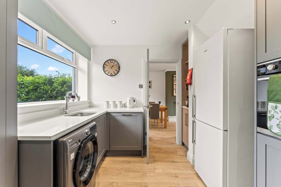 The modern kitchen is fully equipped with everything you could need to cook a meal away from home, featuring a dishwasher, oven, washing machine, toaster, kettle, microwave and coffee machine.