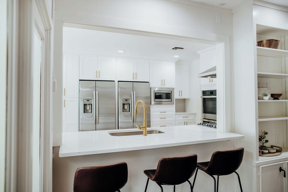 Cook for eighteen without a traffic jam: two French-door fridges, double wall ovens, and an island big enough to prep side by side.