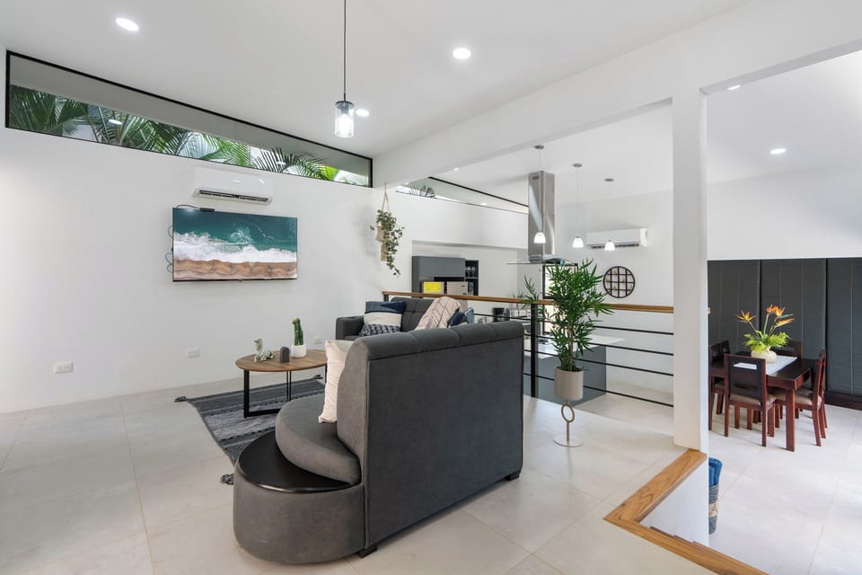 Relax in the spacious living room featuring a modern flat screen TV for movie nights. The ultimate spot to unwind at this luxury Playa Langosta villa in Tamarindo, Costa Rica.